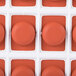 A red silicone round mold with 24 compartments.