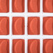 A red silicone tray with 24 tangerine slice molds.