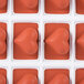 A red silicone heart mold with 24 heart-shaped compartments.