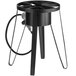 A black Backyard Pro outdoor gas stove on a table with a hose attached.