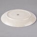 An ivory ceramic platter with a circular design on it.