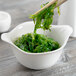 A bowl of seaweed with chopsticks in a Libbey Royal Rideau white porcelain handle bowl.