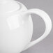 A close-up of a white Libbey Royal Rideau teapot with a handle.