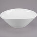 A white Libbey porcelain bowl with a curved edge on a gray background.