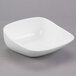 A Libbey white square porcelain bowl on a gray surface.
