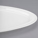 A close-up of a Libbey white porcelain Triform Royal Rideau plate with a curved edge.