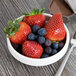 A Libbey Royal Rideau white porcelain bowl filled with strawberries and blueberries.