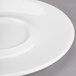 A close-up of a Libbey Royal Rideau white porcelain saucer with a small rim.