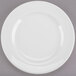 A white Libbey porcelain plate with a wide rim on a gray surface.