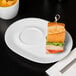 A sandwich on a Libbey white porcelain racetrack plate with a toothpick.