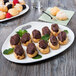 A Libbey white porcelain plate with chocolate covered croissants, mint, and berries.