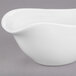A close-up of a white Libbey Royal Rideau porcelain sauce boat with a curved edge.
