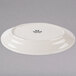 A white Tuxton oval china platter with an embossed pattern on the rim.