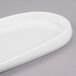 A close-up of a white oval Libbey porcelain tray with a curved edge.