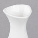A close up of a white vase with a curved shape.