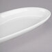 A white oval shaped Libbey Royal Rideau porcelain serving tray with 2 wells.