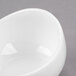 A close up of a Libbey Royal Rideau white porcelain sauce bowl with a small hole in the middle.