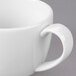 A close up of a white Libbey espresso cup with a handle.