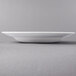 A white Libbey Royal Rideau porcelain bowl with a rim on a white surface.