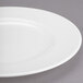 A close-up of a Libbey white porcelain plate with a wide rim on a gray surface.