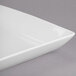 A close-up of a Libbey white square porcelain coupe plate with a square edge.