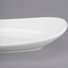 A white Libbey oval porcelain plate with a curved edge.