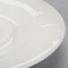 A close-up of a white Reserve by Libbey Royal Rideau porcelain tea saucer with a circular rim.