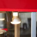 A Satco R20 light bulb on a red counter in a coffee shop.