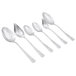A close-up of several silver spoons from the Mercer Culinary 7 Piece Plating Spoon Set.
