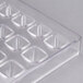A clear plastic mold with triangular holes.
