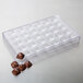 A clear plastic tray with pyramid-shaped chocolate pieces.