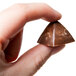 A hand holding a Martellato polycarbonate chocolate pyramid.