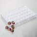 A clear plastic Matfer Bourgeat tray with 36 chocolates.