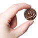 A hand holding a chocolate rose made with a Matfer Bourgeat chocolate mold.