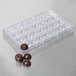 A clear plastic Matfer Bourgeat tray with round chocolate balls.