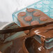 Melted chocolate being poured into a Matfer Bourgeat small cannele chocolate mold.