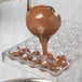 A person pouring chocolate into a Matfer Bourgeat diamond chocolate mold.