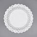 A white Normandy lace doily with a white border on a gray surface.