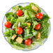 A close up of a salad with tomatoes, lettuce and croutons served in an Arcoroc Fleur glass bowl.