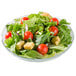 A Fleur glass bowl filled with salad with tomatoes, lettuce, and croutons.