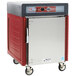 A red and silver Metro insulated holding cabinet with wheels.