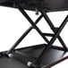 A black Luxor adjustable stand up desktop desk on a black metal stand.