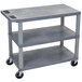 A Luxor grey plastic utility cart with three flat shelves and wheels.