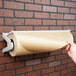 A person using a Bulman paper roll dispenser to cut paper on a wall.