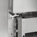 A stainless steel door with a metal hinge box with a screw on the side.