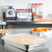 A group of Durable Packaging aluminum foil entree pans with dome lids on a counter.
