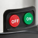A close up of a red round push button with white text on an AvaMix 928PJE17.