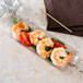 A Fineline clear rectangular tray with shrimp and tomatoes on it.