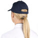 A woman wearing a Choice navy 6-panel cap with a ponytail.