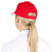 A woman with a ponytail wearing a red Choice 6-panel cap.
